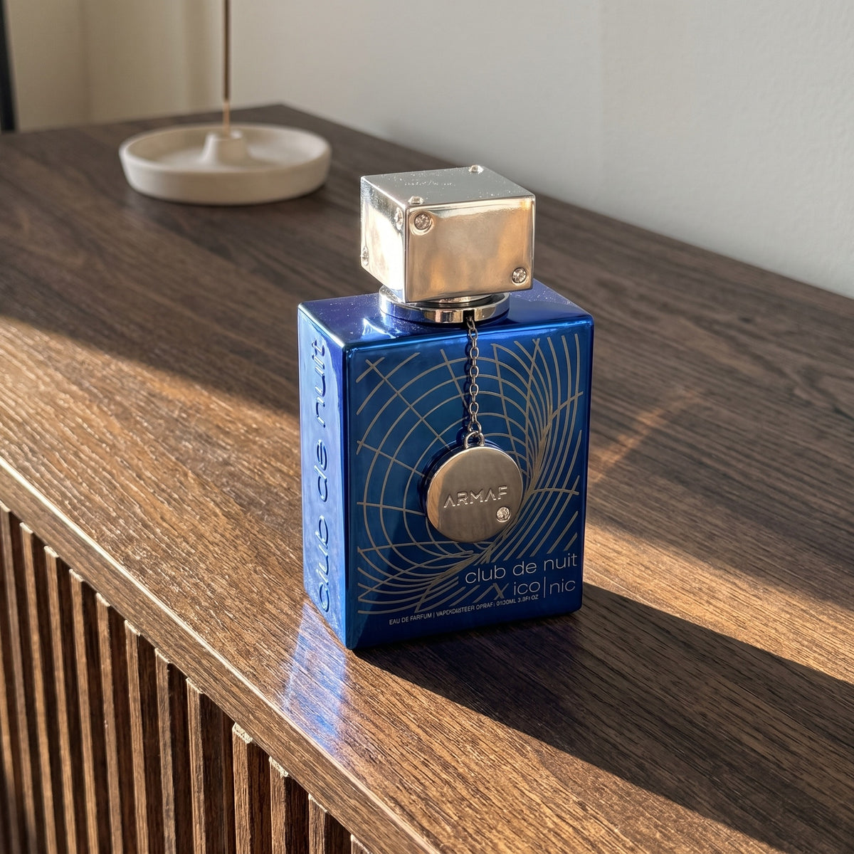 Perfume Armaf Club de Nuit Blue Iconic sobre móvel de madeira com luz natural