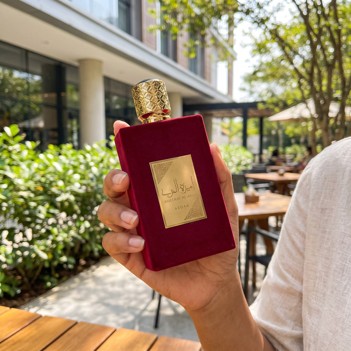 Perfume Asdaaf Ameerat Al Arab sendo segurado em ambiente externo