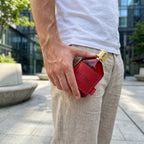 Perfume Dumont Nitro Red segurado em ambiente urbano com luz natural