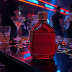 Perfume Dumont Nitro Red em ambiente noturno com iluminação vermelha e azul