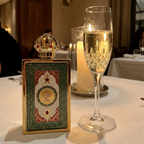 Perfume Lattafa Queen of Arabia ao lado de taça em ambiente de jantar