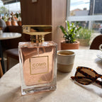 Perfume Maison Alhambra Como Moiselle sobre mesa em ambiente iluminado