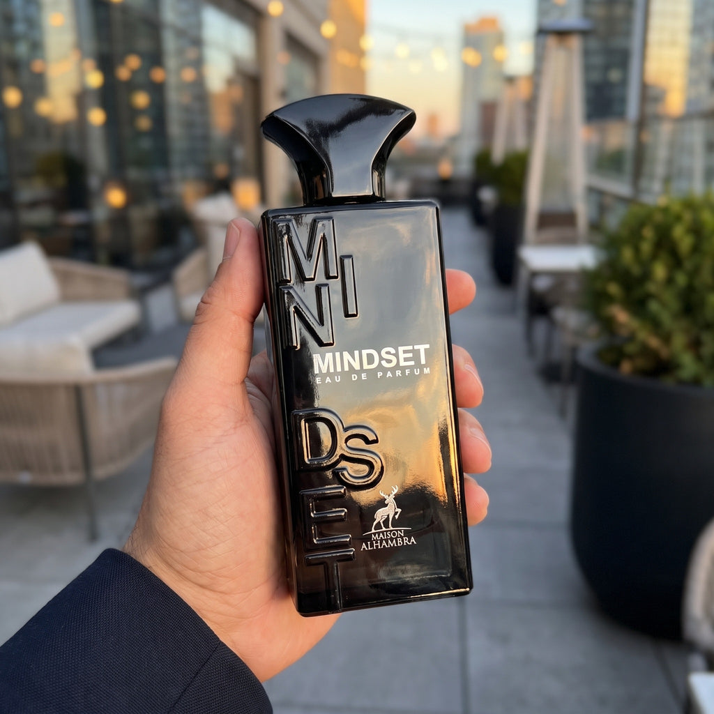 Perfume Maison Alhambra Mindset segurado em uma varanda urbana ao entardecer