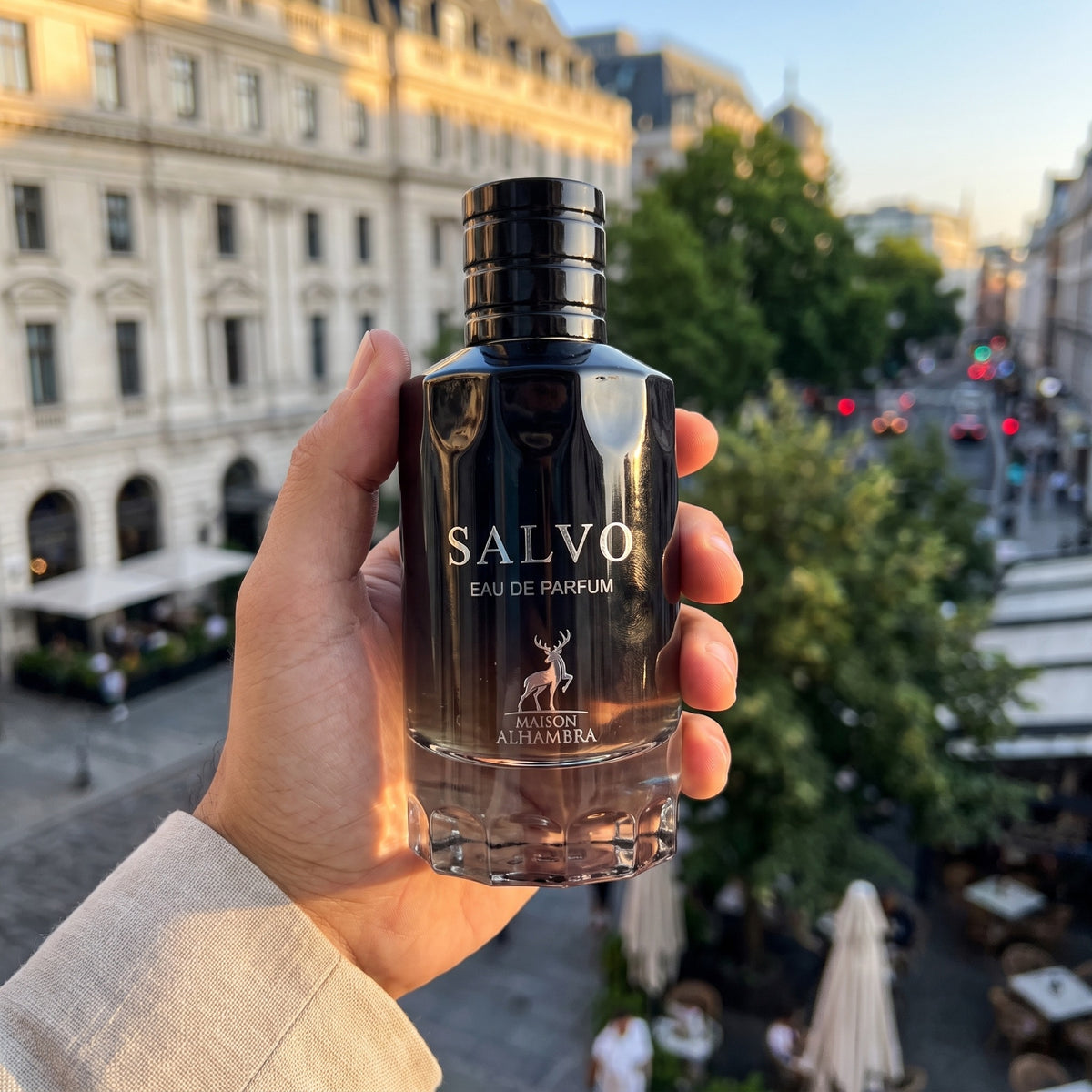 Perfume Maison Alhambra Salvo segurado em ambiente urbano ao entardecer