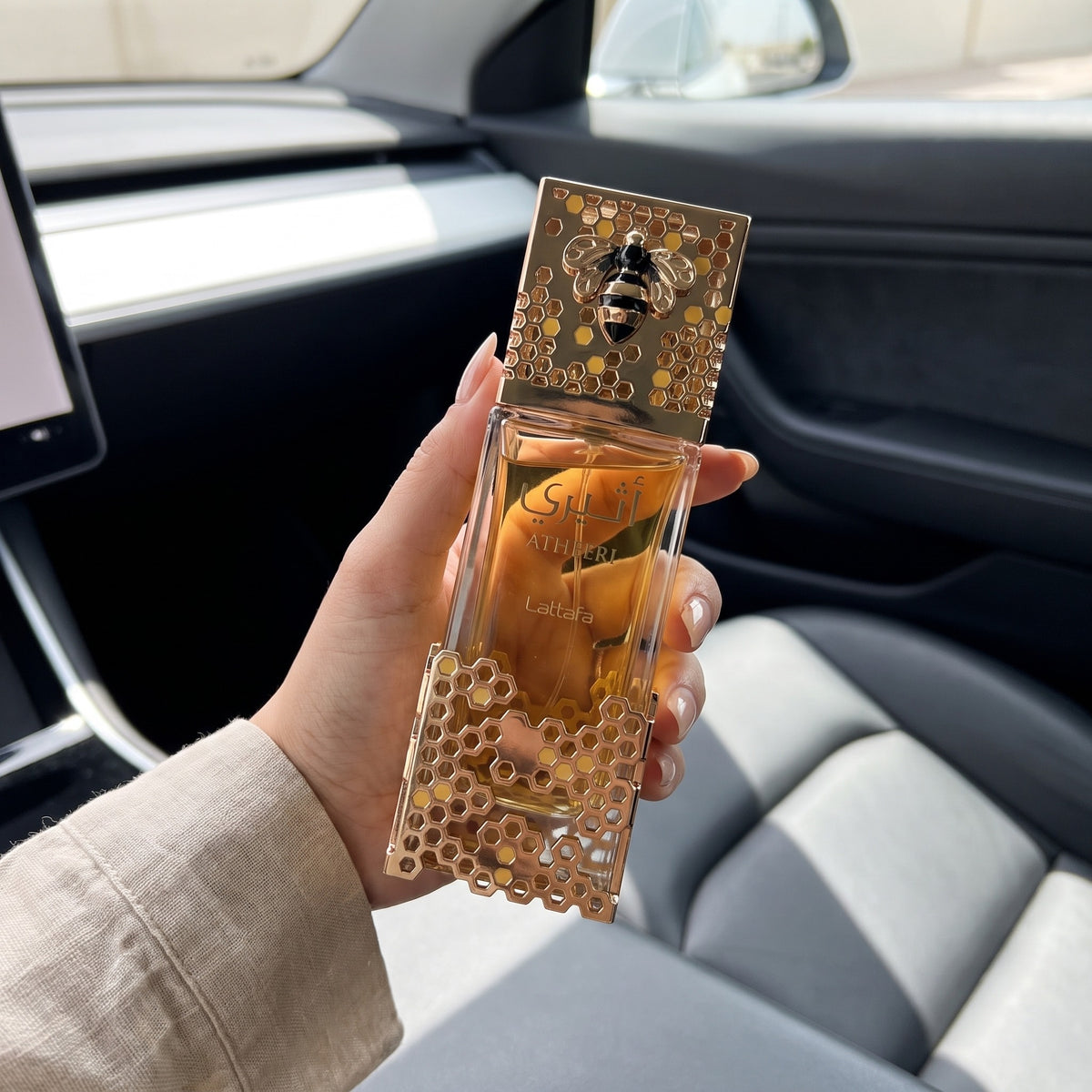 Perfume Lattafa Atheeri EDP feminino em foto lifestyle no carro