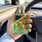 Perfume Rasasi Hawas Verde segurado dentro de um carro com luz natural
