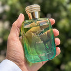 Perfume Rasasi Hawas Verde segurado em ambiente externo ensolarado